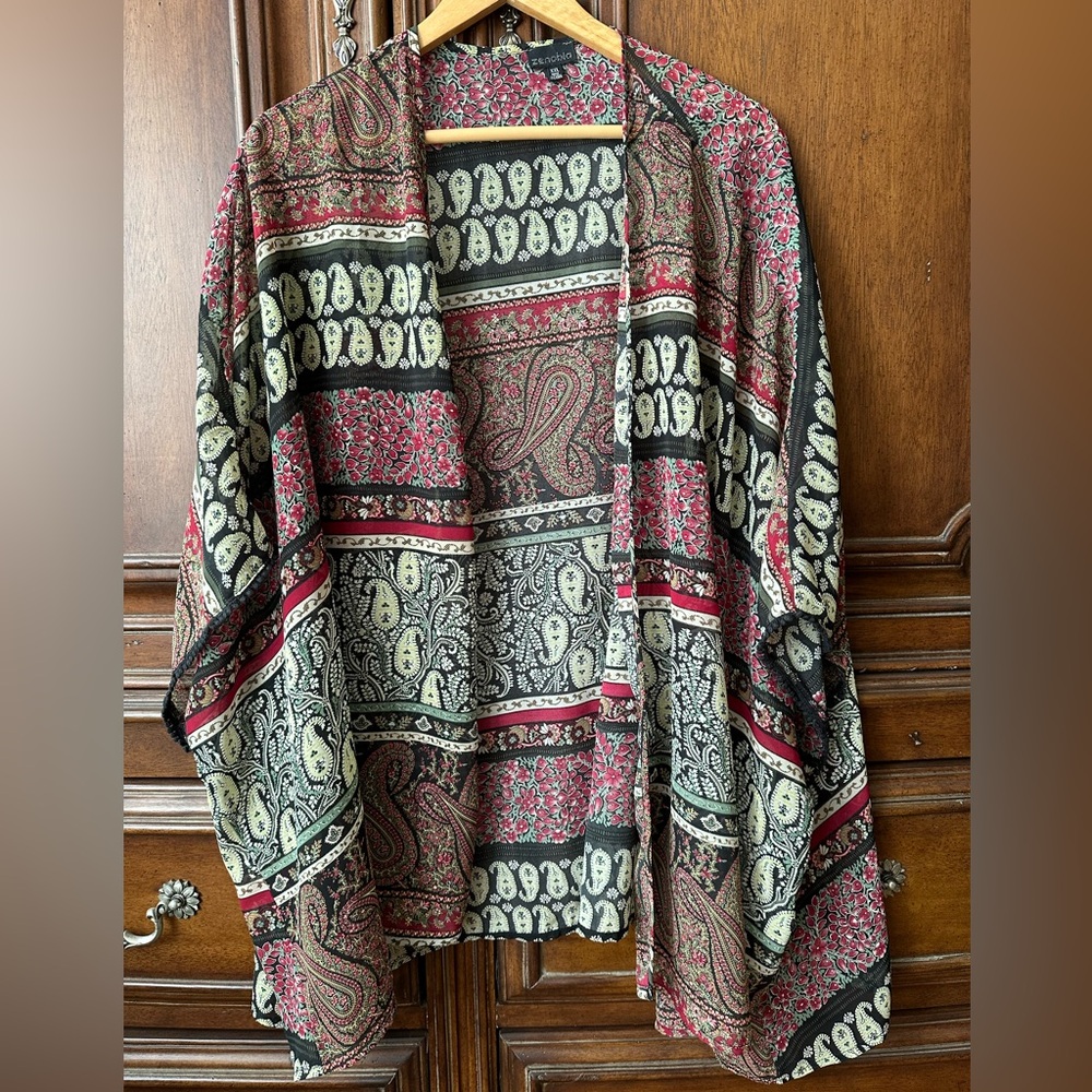 Cape with decorative trim on sleeves